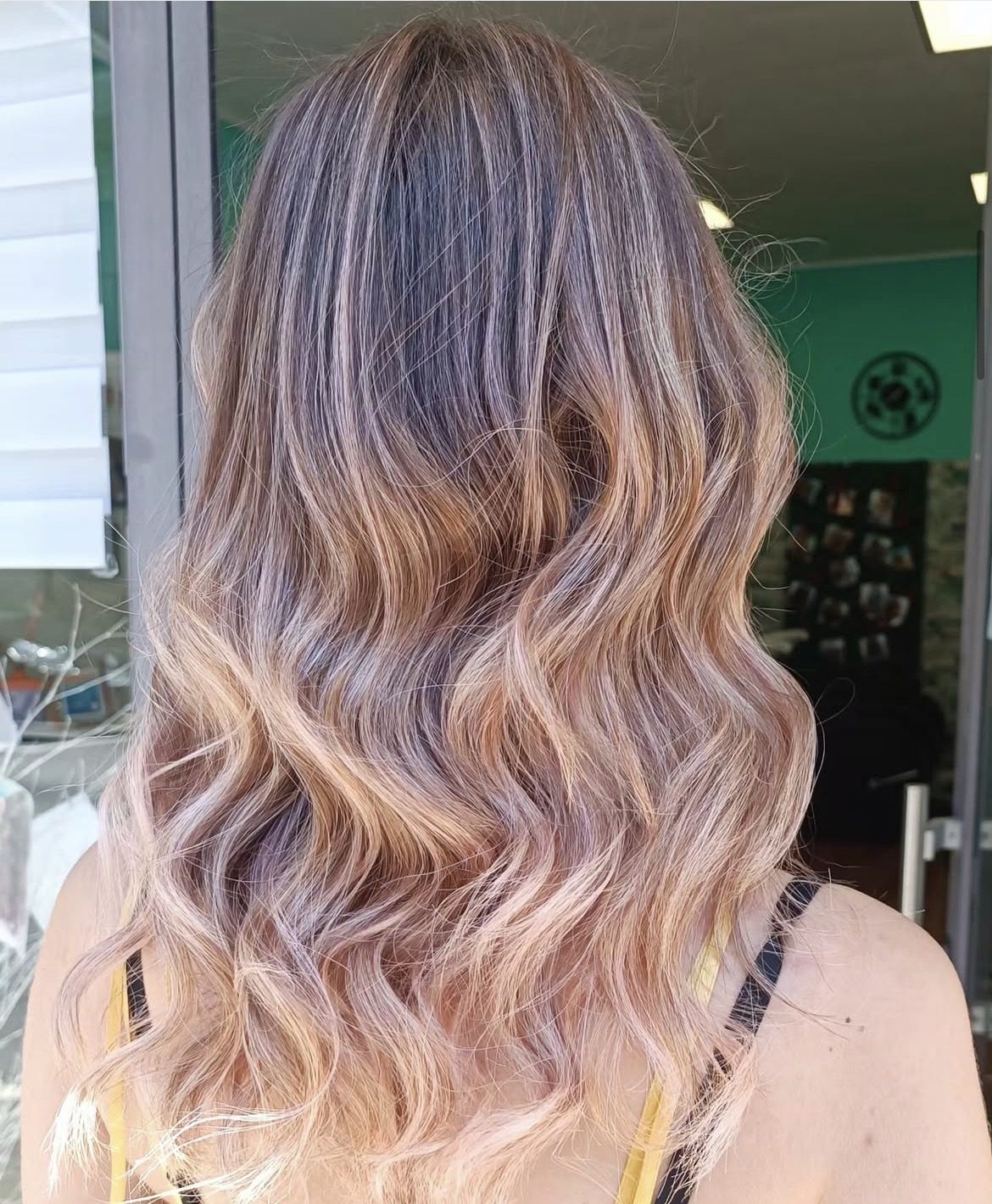 Balayage biondo caldo su capelli mossi, texture morbida e luminosa