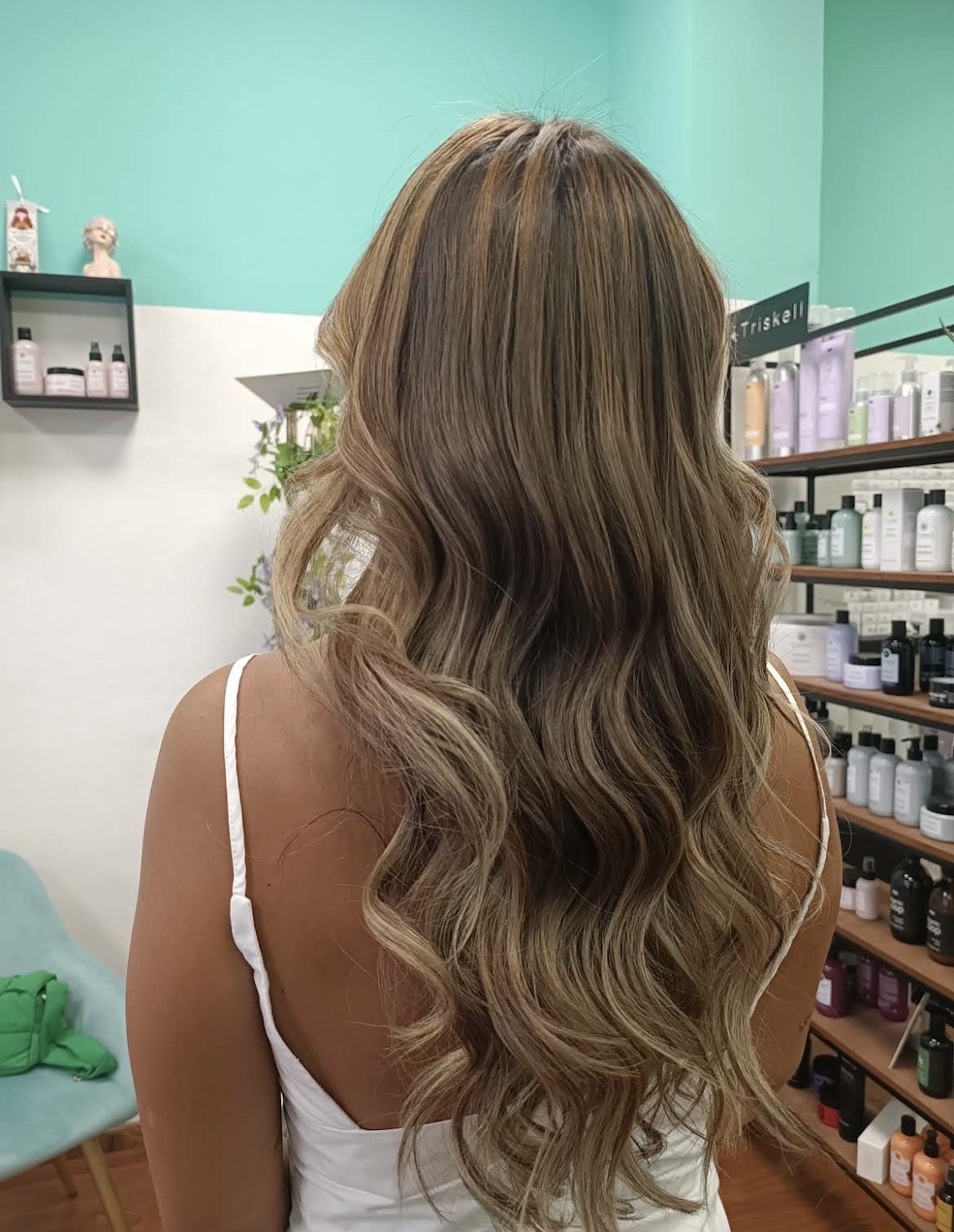 Balayage naturale su capelli mossi accanto ai prodotti Triskell