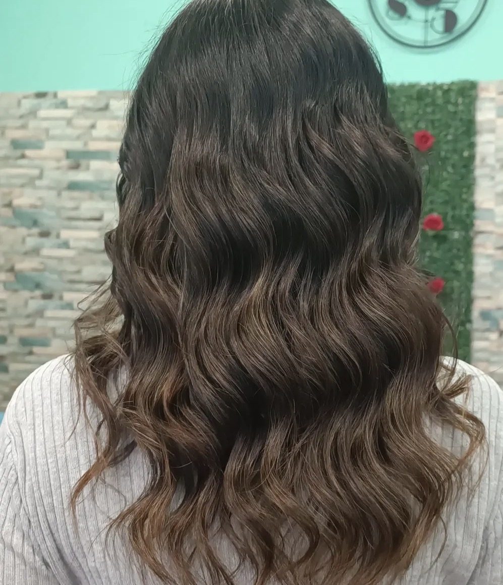 Capelli scuri mossi con dettaglio floreale sullo sfondo