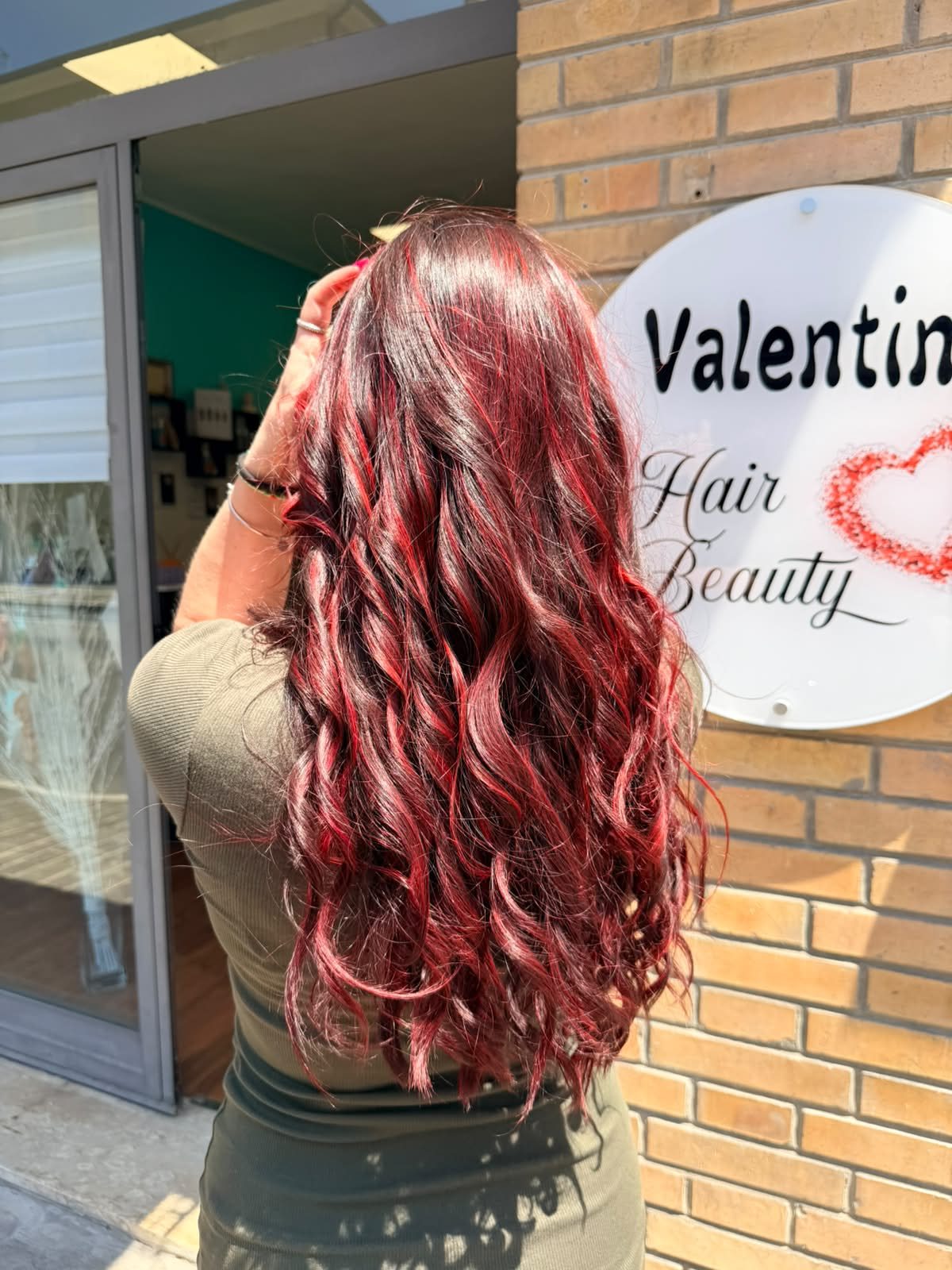 Capelli rossi mossi davanti all'insegna del salone