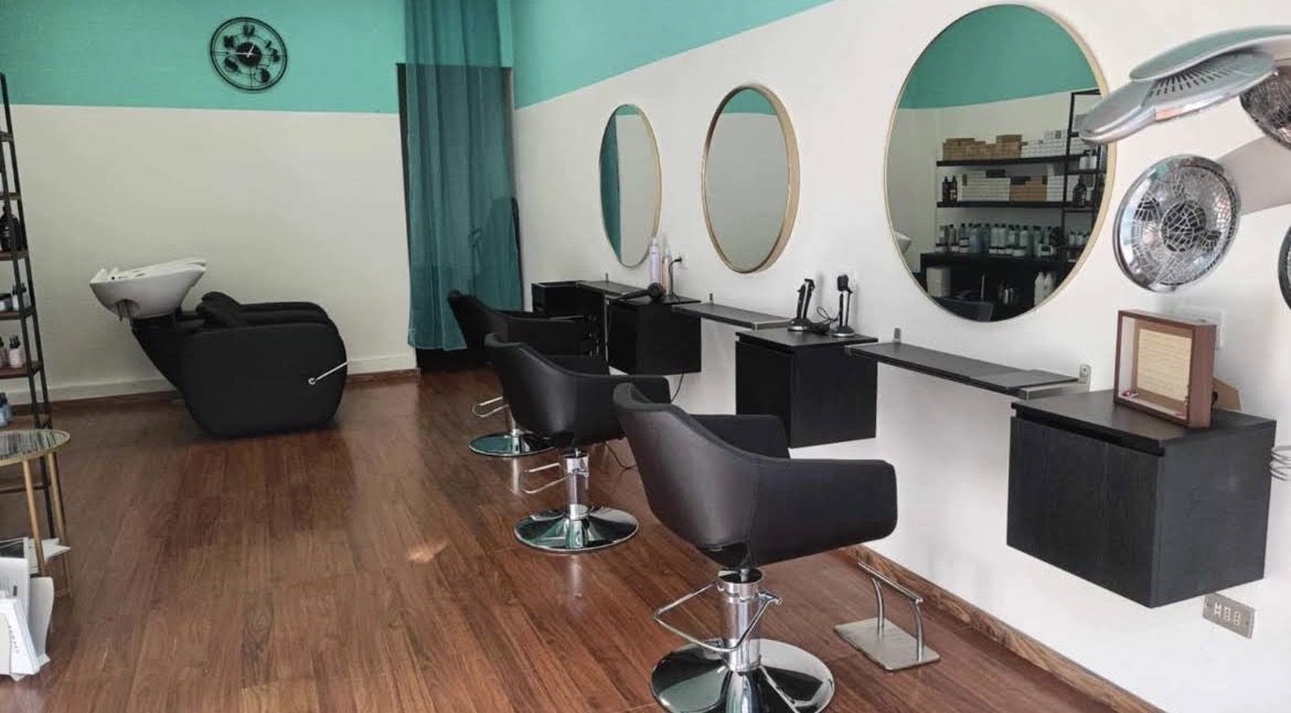 Interno del salone Valentina Hair Beauty con postazioni di lavoro e specchi rotondi
